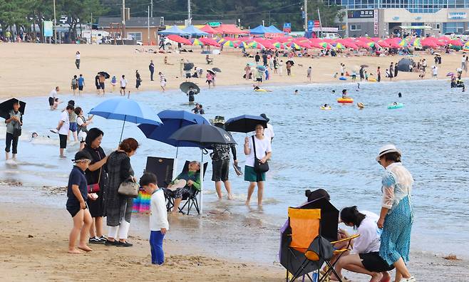 폭염경보가 발효된 18일 오후 인천 중구 을왕리해수욕장을 찾은 시민들이 더위를 식히고 있다. /연합뉴스