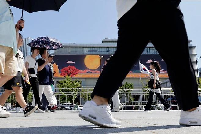 서울 광화문 광장에서 외국인들이 뜨거운 햇살에 양산을 쓰고 걷고 있다.ⓒ뉴시스