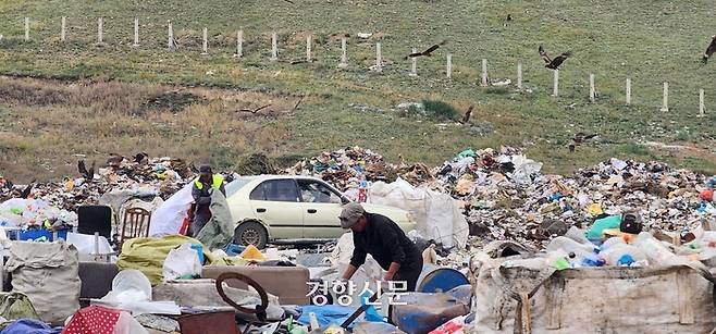 지난달 30일 몽골 수도 울란바토르 인근에 있는 울란촐로트의 쓰레기 적치장에서 주민들이 금속과 플라스틱 등 재활용할 수 있는 물건들을 골라내고 있다. 도시 사람들이 버린 쓰레기더미 속에는 음식 쓰레기도 버려져 있는 탓에  적치장 상공에는 맹금류와 까마귀 등 새들 수백마리가 날아다니고 있었다. 울란촐로트에는 몽골의 급격한 기후변화로 인해 기후난민이 된 유목민 등 도시빈민들이 모여사는 쓰레기마을도 형성돼 있다. 울란바토르 | 김기범 기자