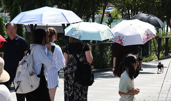 추석 연휴인 지난 16일 서울 종로구 광화문광장에서 외국인 관광객들이 양산을 쓰고 걸어가고 있다. 연합뉴스