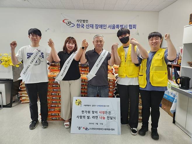 홍은기 한국산재장애인 서울특별시협회장(왼쪽 세번째)이 봉사단원들과 나눔 전달식 기념촬영을 했다.