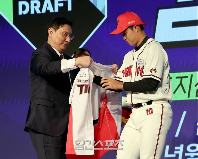 2025 KBO 신인드래프트가 11일 오후 서울 송파구 롯데호텔월드 크리스탈볼룸에서 열렸다. 덕수고 김태형이 KIA에 지명되고 나서 유니폼을 입고있다. 왼쪽은 심재학 KIA 단장. 잠실=정시종 기자 /2024.09.11.