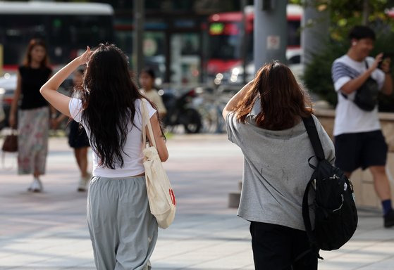 전국 대부분 지역에 폭염특보가 내려진 18일 오후 서울 송파구 잠실네거리에서 시민들이 손으로 햇빛을 가린 채 이동하고 있다. [뉴시스]