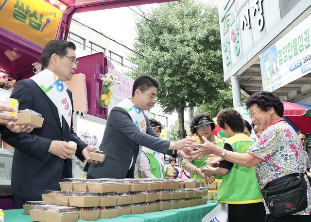 군민들에게 주먹밥과 식혜를 나눠주며 아침밥 먹기를 당부하는 진병영 함양군수(왼쪽부터)와 노춘석 농협 함양군지부장.