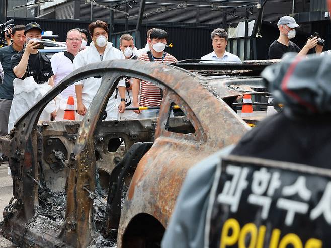 경찰이 8월8일 인천 서구 당하동 한 공업사에서 청라 아파트 전기차 화재 관련 2차 합동감식을 하고 있는 가운데 벤츠사 관계자들이 불 탄 벤츠 전기차를 보고 있다. (사진 = 연합뉴스)