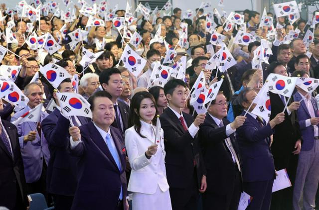 지난해 서울 서대문구 이화여대 대강당에서 열린 78주년 광복절 경축식에서 윤석열 대통령과 김건희 여사가 만세삼창 뒤 태극기를 흔들고 있다. 한국일보 자료사진