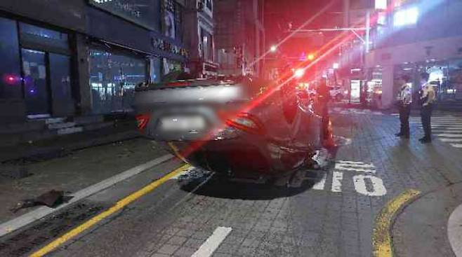 지난 7월 부산 해운대구 중동 해운대구청 어귀삼거리에서 구청 방향으로 달리던 승용차가 가로등을 들이받고 전도됐다. 부산경찰청 제공