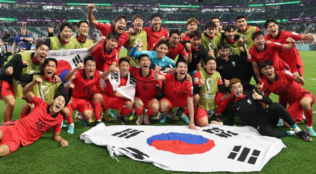 대한민국 축구대표팀 선수들이 2022 카타르 월드컵에서 16강 진출이 확정된 후 기뻐하며 사진촬영을 하고 있다. 동갑내기 친구 손준호(왼쪽 밑에서 네 번째)와 이재성, 손흥민(위쪽 가운데)이 활짝 웃고 있다. 알라이얀=연합뉴스