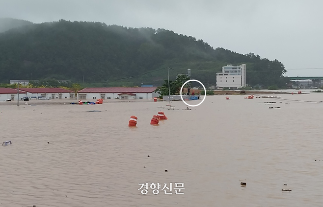 21일 오전 경남 김해시 신문동 도로 일대가 이날 내린 많은 비로 물에 잠겨 있다. 농막 지붕 위에서 고립된 한 주민(흰색 원)이 구조를 기다리고 있다. 경남소방본부 제공.