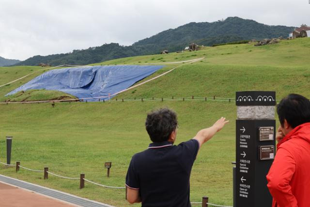 지난 21일 폭우로 일부가 붕괴한 유네스코 세계유산인 경남 김해시 대성동고분군 사고 현장을 22일 시 관계자가 현장을 설명하고 있다. 김해=연합뉴스