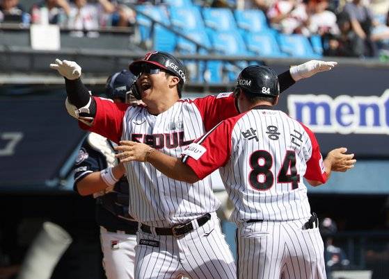 LG 트윈스의 문보경(가운데)이 22일 열린 잠실 라이벌 두산 베어스와의 경기에서 1회 말 3점 홈런을 치고 기뻐하고 있다. 9-5로 이긴 LG는 포스트시즌 진출을 확정했다. [뉴시스]