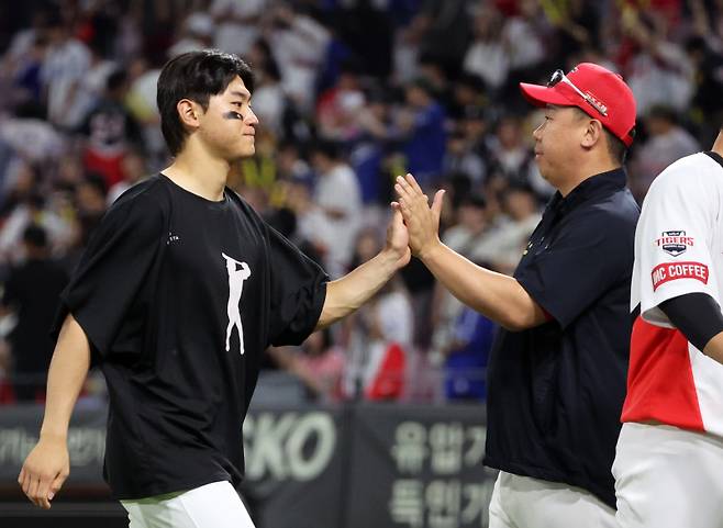 <yonhap photo-4956="">24일 광주기아챔피언스필드에서 열린 프로야구 삼성 라이온즈와 KIA 타이거즈의 경기. 7-1 완승을 이끈 KIA 이범호 감독이 경기를 마치고 김도영과 하이파이브 하고 있다. [연합뉴스]</yonhap>