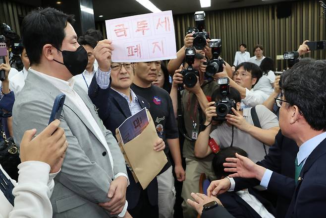 24일 오전 서울 여의도 국회에서 '행복하고 정의로운 대한민국, 금융투자소득세 시행은 어떻게?'라는 주제로 열린 더불어민주당 정책 디베이트에서 개인투자자 단체인 한국주식투자자연합회(한투연) 회원들이 토론 방청을 막는 것에 대해 항의하며 금투세 폐지를 촉구하고 있다. [연합]