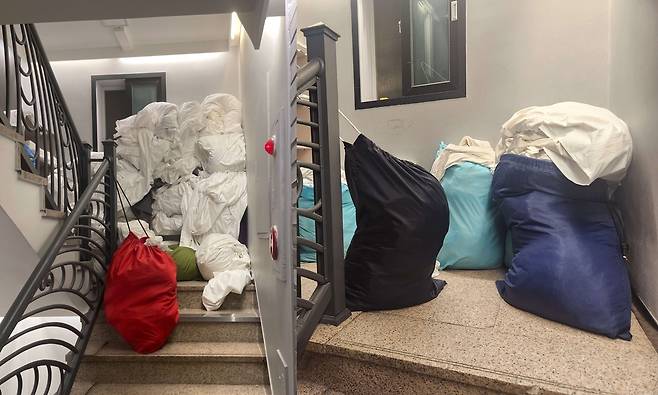 서울 시내 호텔의 비상계단 실태 위급 상황에 대피 통로로 활용돼야 할 비상계단이 세탁물과 쓰레기 등으로 꽉 막혀 있다. 전형적인 안전불감증이라는 지적이다. 왼쪽은 [제보자 제공], 오른쪽은 [촬영 장종우]