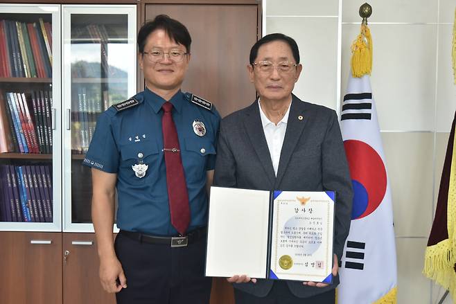 심명섭 속초경찰서장(왼쪽)에게 감사장을 전달 받은 학교배움터지킴이 오신호씨./속초경찰서 제공