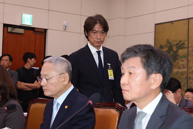 홍명보 축구국가대표팀 감독(가운데)이 24일 국회 문화체육관광위원회 현안 질의 도중 자리로 돌아가고 있다. 정면을 응시하는 유인촌 문화체육관광부 장관과 정몽규 KFA 회장(앞줄 왼쪽부터).  뉴시스