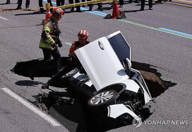 땅 꺼짐 사고 차량 살펴보는 소방 (서울=연합뉴스) 서대연 기자 = 지난 8월 29일 오전 서울 서대문구 연희동 성산로에서 발생한 땅 꺼짐 사고 현장에서 소방 관계자들이 사고 차량을 살펴보고 있다. 2024.8.29 dwise@yna.co.kr