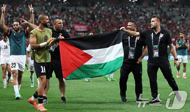 5일 오후 서울 마포구 서울월드컵경기장에서 열린 2026 국제축구연맹(FIFA) 북중미 월드컵 아시아 3차 예선 B조 1차전 대한민국과 팔레스타인의 경기에서 0대 0 무승부로 경기가 끝나자 팔레스타인 코치진이 국기를 든 채 기뻐하고 있다. 2024.9.5/뉴스1 ⓒ News1 박지혜 기자