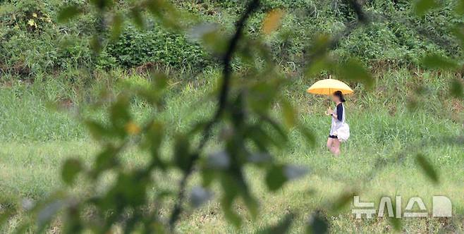 [전주=뉴시스] 김얼 기자 = 전북 전주시 삼천을 찾은 시민이 우산으로 비를 피하며 길을 지나고 있다. 2024.09.20. pmkeul@newsis.com