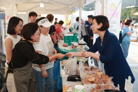 오영주 중소벤처기업부 장관이 지난 10일 서울 종로 청계광장에서 열린 ‘동행 축제 전통시장 판매전’에서 판매 부스를 둘러보고 제품을 구매하고 있다. 중소벤처기업부