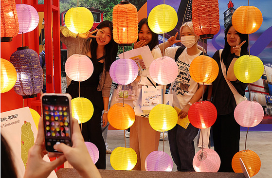 Visitors pose for a photo at the Taiwanese booth at the 2024 Busan International Travel Fair at the Bexco convention center on Friday. [YONHAP]