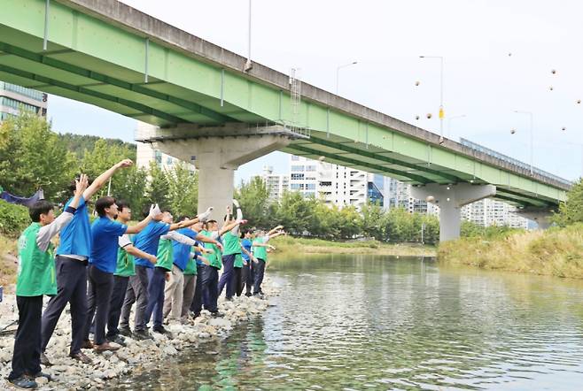 26일 경남 창원 광려천에서 하이트진로 임직원들이 환경정화활동을 진행하고 있다. 하이트진로