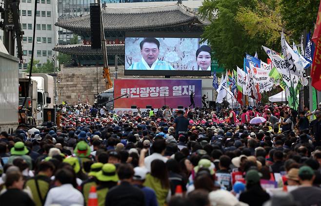 친야 성향 전국민중행동과 윤석열정권퇴진운동본부 등이 28일 오후 서울 숭례문 앞에서 개최한 ‘윤석열 정권 퇴진 시국대회’에서 참석자들이 전광판에 띄워진 윤석열 대통령과 김건희 여사 영상을 보고 있다. 이날 참가자들은 행사를 마치고 용산 대통령실을 향해 행진했는데, 일부 참가자가 연막탄을 터뜨려 경찰과 대치하기도 했다./뉴시스