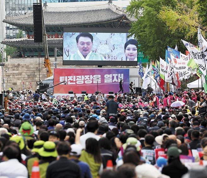 숭례문 앞 尹 퇴진 집회… 용산까지 행진 - 친야 성향 전국민중행동과 윤석열정권퇴진운동본부 등이 28일 오후 서울 숭례문 앞에서 개최한 '윤석열 정권 퇴진 시국대회'에서 참석자들이 전광판에 띄워진 윤석열 대통령과 김건희 여사 영상을 보고 있다. 이날 참가자들은 행사를 마치고 용산 대통령실을 향해 행진했는데, 일부 참가자가 연막탄을 터뜨려 경찰과 대치하기도 했다. /뉴시스