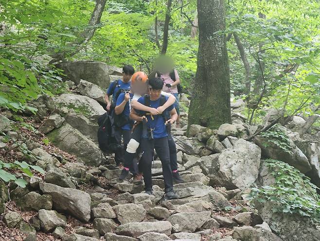 산에서 요구조자를 업고 내려오는 산악구조대원들 [강원특별자치도소방본부 환동해특수대응단 제공. 재판매 및 DB 금지]