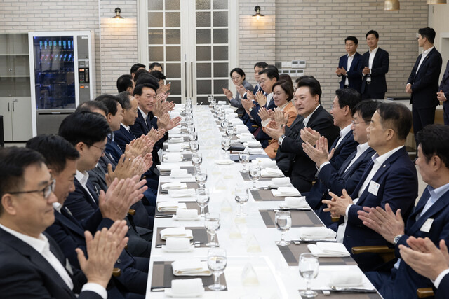 윤석열 대통령이 2일 서울 용산 대통령실 앞 파인그라스에서 열린 국민의힘 원내지도부 초청 만찬에서 추경호 원내대표 등 참석 의원들과 함께 박수를 치고 있다. 연합뉴스