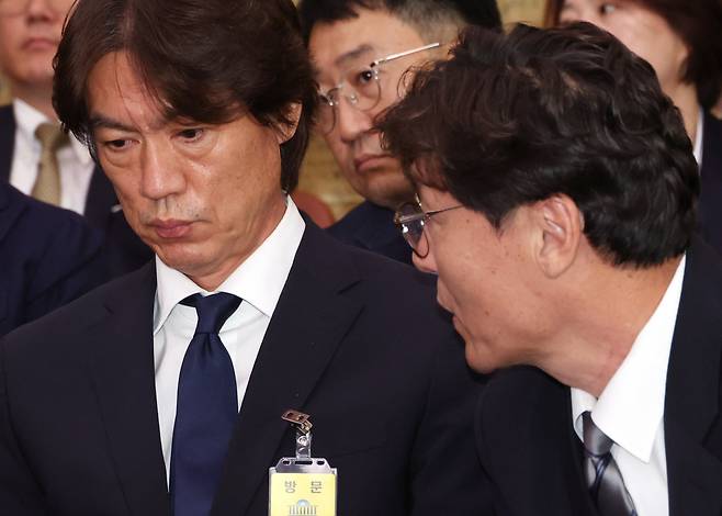 Men's national soccer team coach Hong Myung-bo (left) speaks with former Korea Football Association Technical Director Lee Lim-saeng at the parliamentary committee on culture, sports and tourism at the National Assembly in Seoul on Sept. 24. (Yonhap)