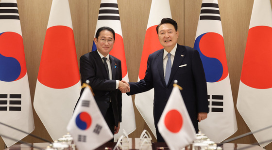 Korean President Yoon Suk Yeol, right, and Japanese Prime Minister Fumio Kishida shake hands during their bilateral summit in Seoul on Sept. 6. [JOINT PRESS CORPS]