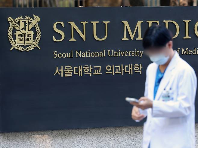 A person walks by a plaque of Seoul National University's College of Medicine in central Seoul on Wednesday. [NEWS1]