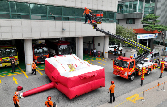 지난 8월 26일 경기도 수원시 권선구 수원남부119안전센터에서 소방관들이 화재현장 대응력 강화를 위한 에어매트(공기안전매트) 전개 훈련을 하고 있다. 사진은 해당 기사와 직접적 연관이 없음.