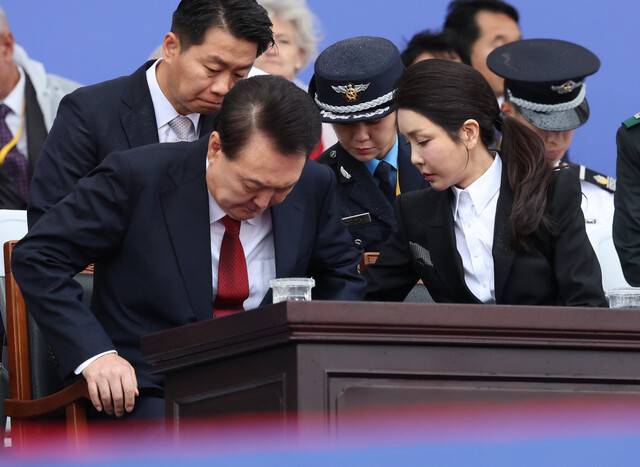 윤석열 대통령의 부인 김건희 여사가 1일 성남 서울공항에서 열린 건군 76주년 국군의날 기념식에서 윤 대통령 의자의 빗물을 닦아 주고 있다. 연합뉴스