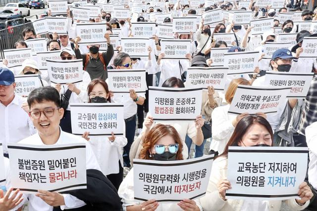 전국 의과대학 교수들과 학생들이 3일 서울 용산구 대통령실 앞에서 열린 '의학교육평가원 무력화 저지를 위한 전국의과대학 교수 결의대회'에서 구호를 외치고 있다. 뉴스1