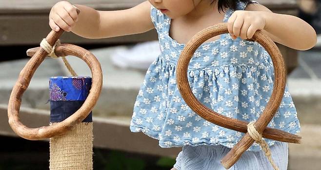 한 어린이가 남산골 한옥마을 마당의 민속놀이를 하고 있습니다. 고리를 던져서 목표 지점에 넣는 놀이인데 아이는 들고 가서 덩크슛으로 넣습니다. 천진난만하고 기발하게 성공하네요. 김호영 기자