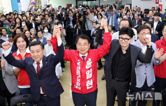 한동훈 국민의힘 대표가 지난달 28일 부산 금정구 윤일현 금정구청장 후보 선거사무실 개소식에 참석, 윤 후보의 손을 들고 지지를 호소하고 있다. 뉴시스 제공