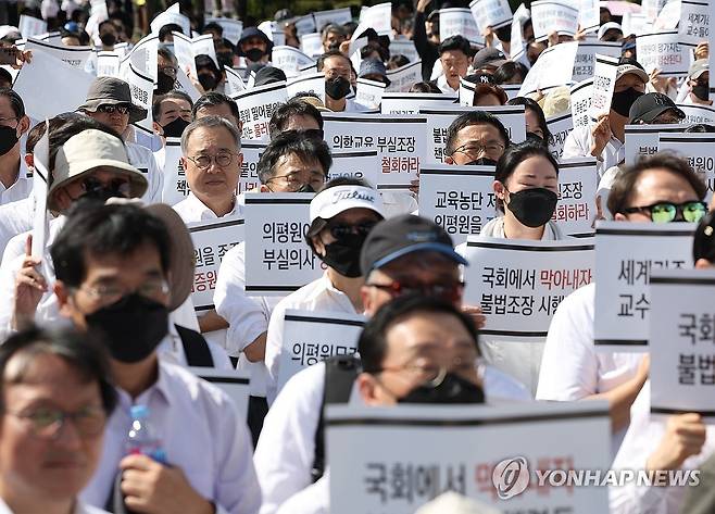 한국의학교육평가원 무력화 저지 결의대회 (서울=연합뉴스) 이지은 기자 = 의대교수들이 3일 오후 서울 용산구 대통령실 인근에서 열린 한국의학교육평가원 무력화 저지 결의대회에서 손팻말을 들고 있다. 2024.10.3 jieunlee@yna.co.kr