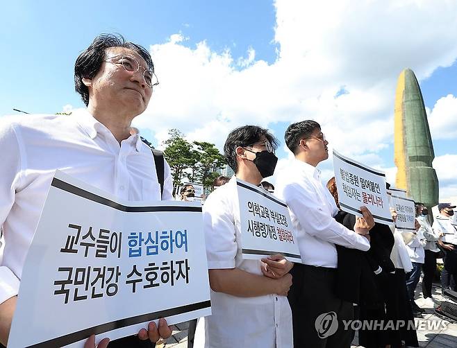 한국의학교육평가원 무력화 저지 결의대회 (서울=연합뉴스) 이지은 기자 = 의대교수들이 3일 오후 서울 용산구 대통령실 인근에서 열린 한국의학교육평가원 무력화 저지 결의대회에서 손팻말을 들고 구호를 외치고 있다. 2024.10.3 jieunlee@yna.co.kr