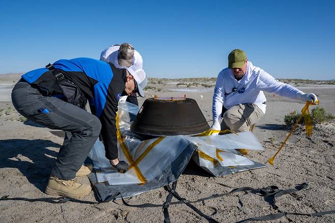 NASA 과학자들이 2023년 9월 24일 무인 탐사선 오시리스-렉스가 미국 유타주 사막에 떨어뜨린 캡슐을 회수하고 있다./NASA