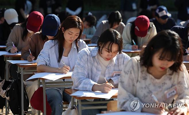 전 국민 받아쓰기 대회 '모두가 집중 또 집중' (서울=연합뉴스) 김도훈 기자 = 제578돌 한글날을 기념하는 2024 한글주간(4일~10일) 첫날인 4일 오후 서울 경복궁 흥복전에서 열린 '전 국민 받아쓰기 대회'에서 참가자들이 제시문을 답안지에 적고 있다. 2024.10.4 superdoo82@yna.co.kr