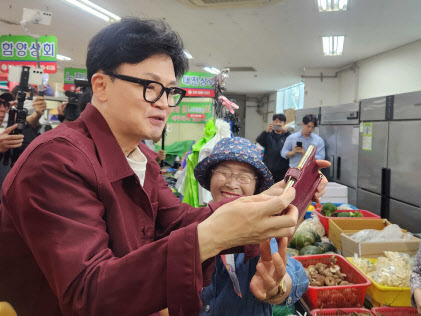 한동훈 국민의힘 대표가 5일 부산 금정구 남산시장에서 열린 ‘행복한 남산 금정애(愛) 와야제‘ 축제 현장을 방문해 윤일현 금정구청장 후보의 지지를 호소하며 시민과 함께 셀카를 찍고 있다. (사진=뉴시스)