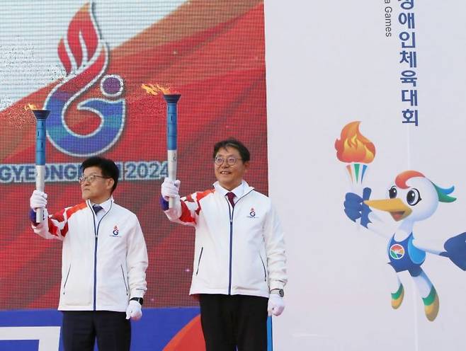 홍태용 경남 김해시장(오른쪽)이 105회 전국체육대회와 제44회 전국장애인체육대회 성화를 받아 들고 있다. [사진=이세령 기자]