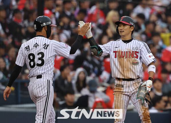 6일 오후 서울 송파구 잠실야구장에서 열린 2024 프로야구 준플레이오프 2차전 kt 위즈와 LG 트윈스의 경기, 6회말 1사 만루상황 LG 신민재가 좌익수 앞 안타를 날린 후 실책을 틈타 3루까지 진루에 성공한 뒤 정수성 코치와 하이파이브를 하고 있다. 사진┃뉴시스