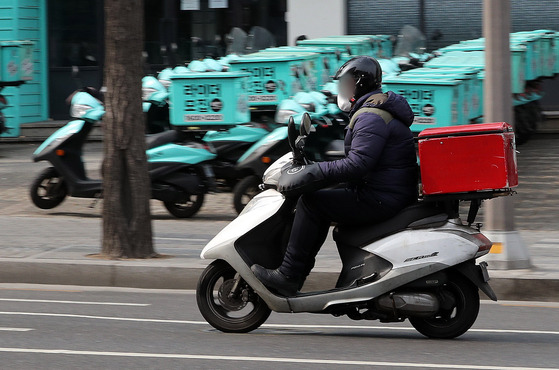 A delivery driver passes by Baemin Riders' center in Gangnam District, southern Seoul, on Feb. 21, 2022. Baemin Riders is food delivery app Baedal Minjok's part-time food delivery service. [NEWS1]