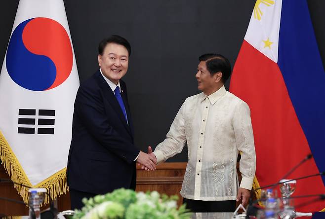 President Yoon Suk Yeol (left) shakes hands with the Philippines President Ferdinand Marcos Jr. during their summit at Malacanang Palace in Manila on Monday. (Yonhap)