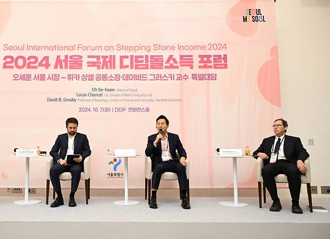 Seoul Mayor Oh Se-hoon (center) speaks during a special plenary session during the Seoul International Forum on Stepping Stone Income with Lucas Chancel, co-director of World Inequality Lab (left) and sociology professor David B. Grusky from Stanford University at Dongdaemun Design Plaza on Monday. (Seoul Metropolitan Government)