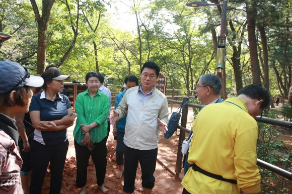 박준희(오른쪽 세 번째) 서울 관악구청장이 지난달 30일 관악산공원 신림계곡지구 황톳길에서 주민들과 함께 맨발 걷기를 하며 대화하고 있다. 관악구 제공