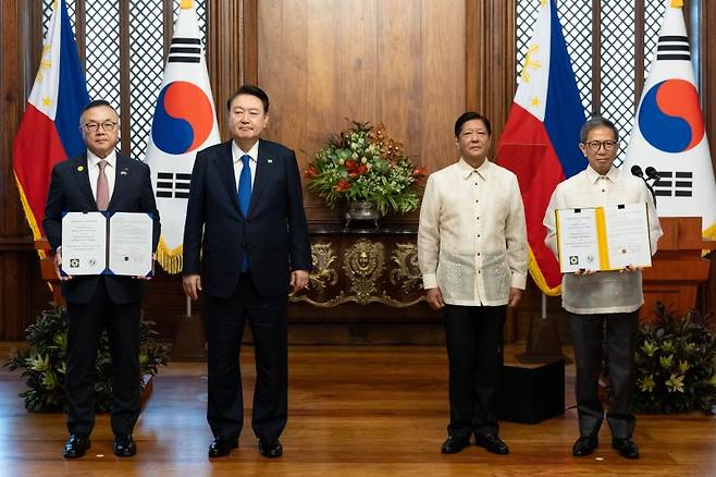 황주호 한국수력원자력 사장과 라파엘 로띨리야 필리핀 에너지부 장관이 7일 오전(현지시간) 필리핀 마닐라 말라카냥 대통령궁에서 윤석열 대통령과 페르디난드 마르코스 필리핀 대통령이 임석한 가운데 한·필리핀 바탄 원전 건설 재개 타당성 조사 협력에 관한 양해각서(MOU)를 교환한 뒤 기념촬영을 하고 있다. 사진=연합뉴스